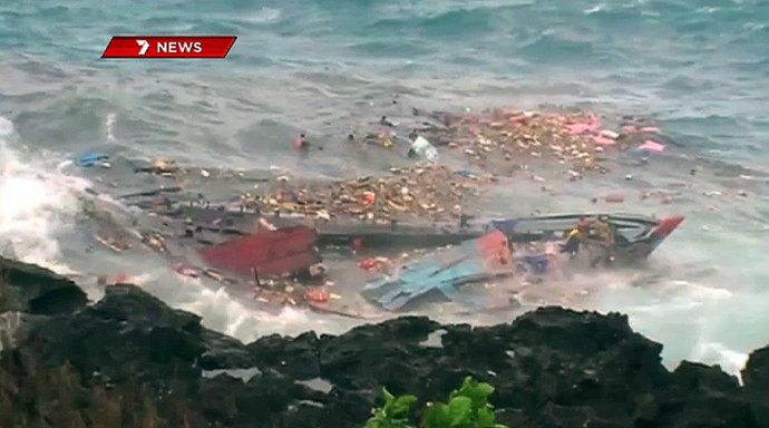 December 16, 2010 photo shows people floating amid and hanging onto the splintered remains of the wooden boat carrying refugees travelling from Asia after it smashed into the rocky coastline of Christmas Island (AFP Photo / Channel 7)