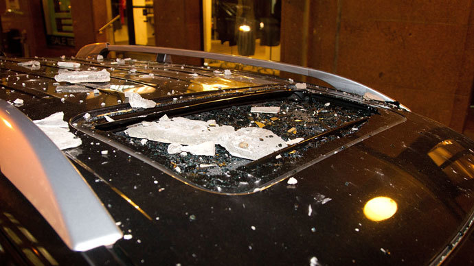 A car is damaged by debry from an old office building that were damaged after a 6.5 magnitude earthquake hit Wellington on July 21, 2013.(AFP Photo / Marty Melville)