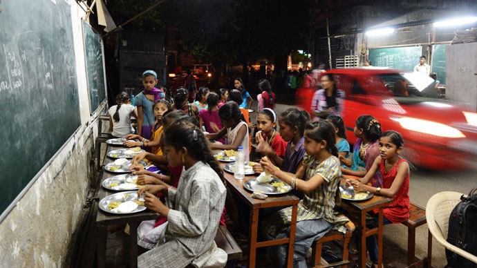 Indian students eat a meal at the Footpath School in Ahmedabad on late July 20, 2013.(AFP Photo / Sam Panthaky) 