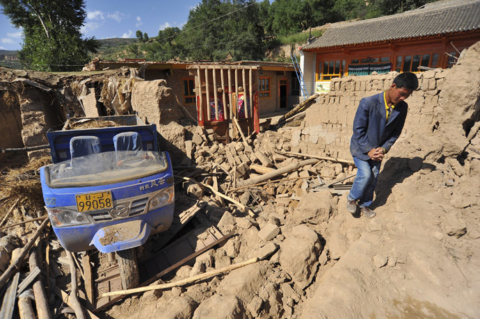 A man walks past a collapsed house after a 6.6 magnitude earthquake in Minxian county, Dingxi, Gansu province, July 22, 2013. (Reuters)