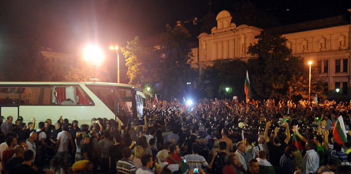 Protestors face Bulgarian riot policemen making way for lawmakers and parliament staff driven in a bus during an anti-government protest in Sofia on July 23, 2013. (AFP Photo/Dimitar Dilkoff)