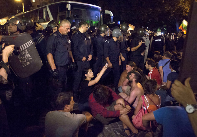 Protesters opposing the Socialist-led government try to stop a heavily guarded bus trying to get deputies out of the parliament where they had been discussing budget measures, in Sofia July 23, 2013. (Reuters)
