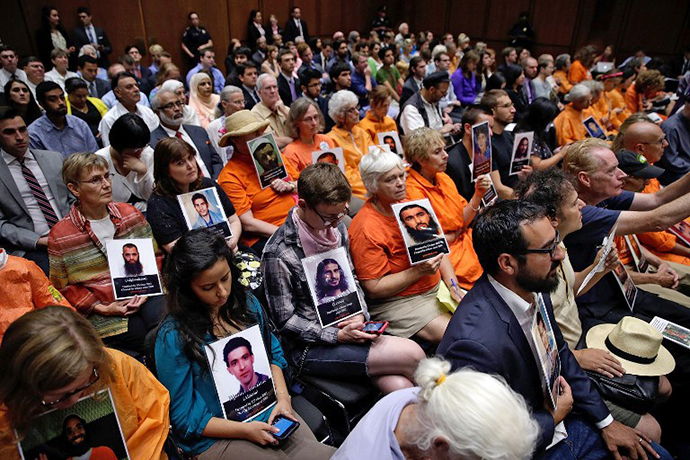 Supporters of closing the Guantanamo Bay Naval Base detention facility hold pictures of prisoners being held at the facility while viewing a hearing of the Senate Judiciary Committee July 24, 2013 in Washington, DC. (AFP Photo / Win Mcnamee)