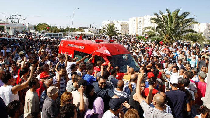 People walk beside the ambulance carrying the body of assassinated Tunisian opposition politician Mohamed Brahmi in Tunis July 25, 2013.(Reuters / Zoubeir Souissi)