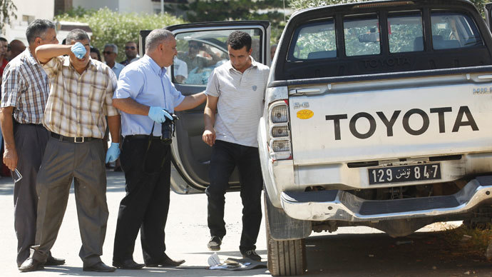 Forensic inspectors examine the car of Tunisian opposition politician Mohamed Brahmi, who was shot dead outside his home, in Tunis July 25, 2013.(Reuters / Zoubeir Souissi)