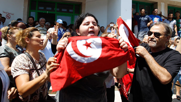 Assassinated Tunisian opposition politician Mohamed Brahmi's daughter Balkis (C) holds a Tunisian flag as she mourns his death in Tunis July 25, 2013. (Reuters / Zoubeir Souissi)