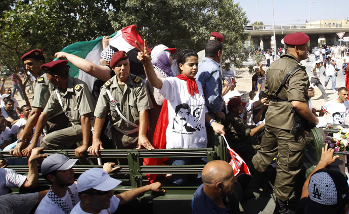 The daughter (C) of slain Tunisian opposition politician Mohamed Brahmi gestures during his funeral procession towards the nearby cemetery of El-Jellaz, where he is to be buried, in Tunis July 27, 2013. (Reuters/Zoubeir Souissi)