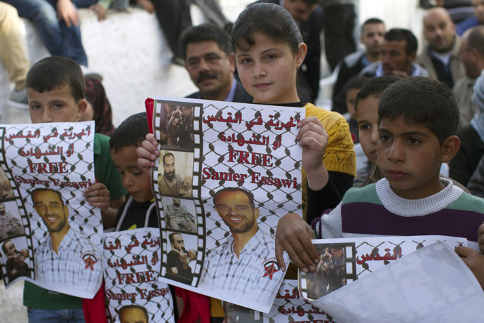 Young Palestinians hold portraits of Samer Issawi, a Palestinian prisoner who is on a long-term hunger strike, during a rally to ask for his release in the West Bank village of Abu Dis, on the outskirts of Jerusalem. (AFP Photo/Ahmad Gharabli)