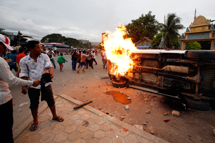 People set a police car on fire during a clash at the end of election day in Phnom Penh July 28, 2013 (Reuters / Samrang Pring)
