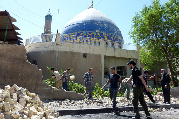 Iraqis remove the stones of a wall that was destroyed in a car bombing outside Ahl al-Bayya' mosque on July 29, 2013 in south eastern Baghdad. (AFP Photo / Ali Al-Saadi)