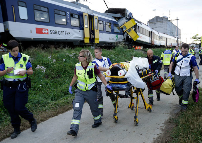 Swiss rescue workers wheel a wounded person on a stretcher after two regional trains crashed head on near Granges-Pres-Marnand near Payerne in western Switzerland July 29, 2013.(Reuters / Denis Balibouse)