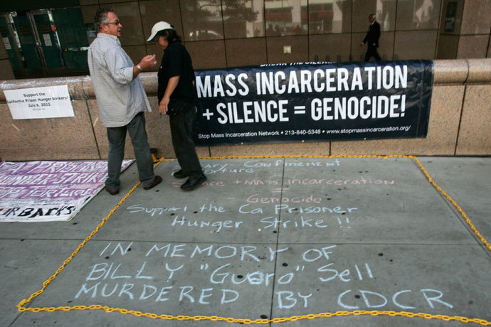 Keith James (R) and "Dee" stand near signage during a rally supporting hunger strikers in the California prison system in Los Angeles, California July 29, 2013. (Reuters / Jonathan Alcorn)