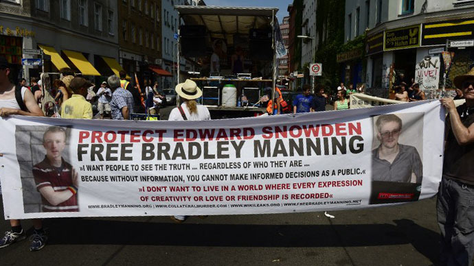 Demonstrators hold a banner in support of former US agent of the National Security Agency, Edward Snowden and U.S. Army Private First Class Bradley Manning as they take part in a protest against the US National Security Agency (NSA) collecting German emails, online chats and phone calls and sharing some of it with the country's intelligence services in Berlin on July 27, 2013. (AFP Photo / John Macdougall)