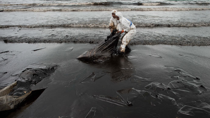 People work to clean up Ao Phrao beach after a major oil slick hit the island of Ko Samet on July 31, 2013.(AFP Photo / Nicolas Asfouri)