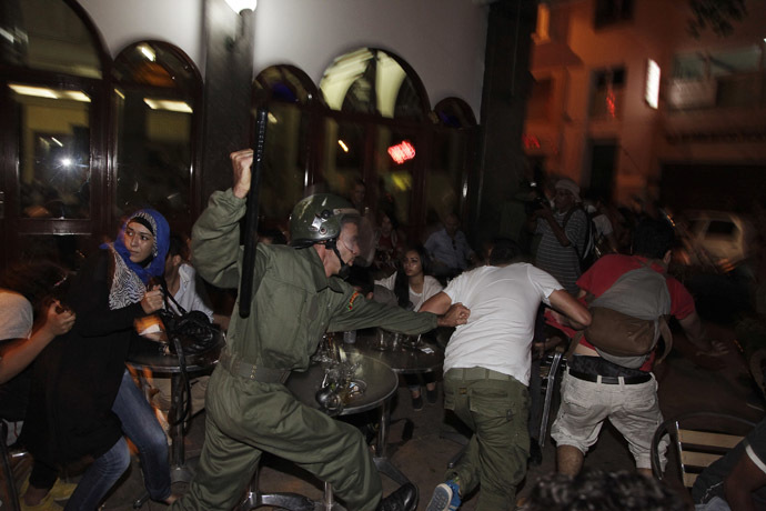 A riot policeman charges at protesters during a demonstration against a royal pardon for a Spanish paedophile, in Rabat late August 2, 2013. (Reuters)