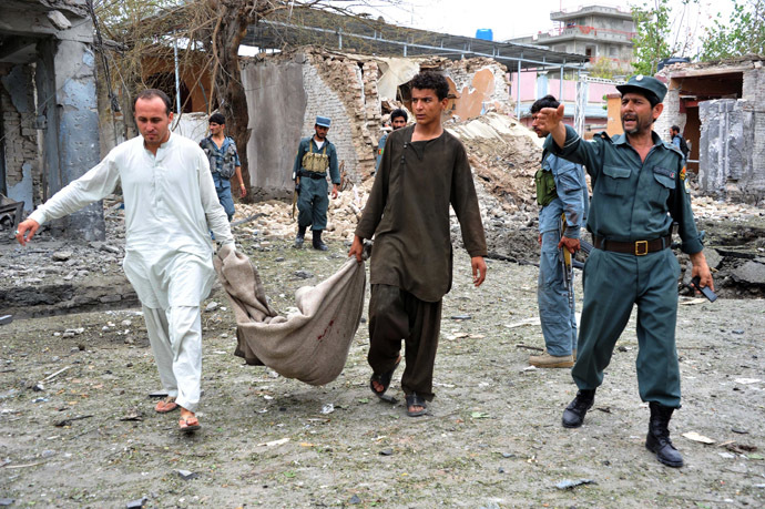 Afghan residents use a blanket to carry the body of a child at the site of a suicide attack in front of the Indian consulate in Jalalabad on August 3, 2013. (AFP Photo/Noorullah Shirzada)