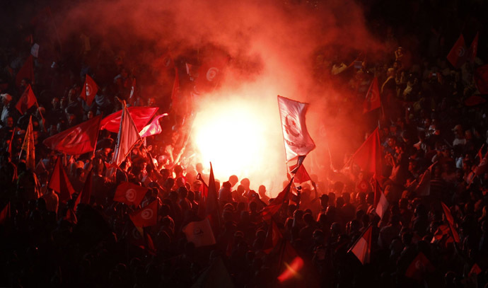 Supporters of the Islamist Ennahda movement light flares and wave flags during a rally at Kasbah Square in Tunis August 3, 2013. (Reuters/Zoubeir Souissi)