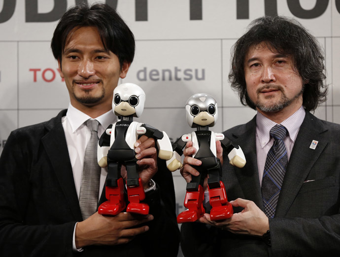 Tomotaka Takahashi (L), CEO of Robo Garage Co and project associate professor, research centre for advanced science and technology, the University of Tokyo, and Fuminori Kataoka, project general manager in the Product Planning Group of Toyota Motor Corp, hold humanoid communication robots Kirobo and Mirata respectively during their unveiling in Tokyo June 26, 2013. (Reuters/Toru Hanai)