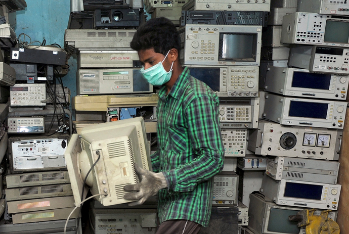 An Indian worker carries a defunct CRT Monitor for disassembly at Ash Recyclers, a government approved e-waste management firm in Bangalore (AFP Photo / Manjunath Kiran) 