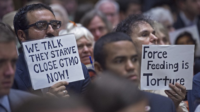 Protesters in support of closing the US Guantanmo Naval Base detention facility hold signs as they listen in the public audience area of the Senate Judiciary Committee, The Constitution, Civil Rights and Human Rights Subcommittee hearing on "Closing Guantanamo: The National Security, Fiscal, and Human Rights Implications.", July 24, 2013, on Capitol Hill in Washington, DC. (AFP Photo / Paul J. Richards)