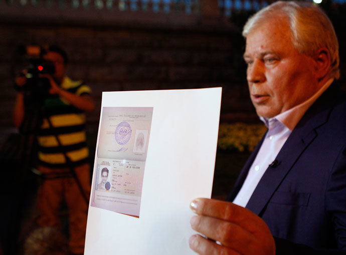 Lawyer Anatoly Kucherena shows a picture of fugitive former US spy agency contractor Edward Snowden in his new refugee documents granted by Russia during a news conference in Moscow August 1, 2013. (Reuters / Maxim Shemetov)