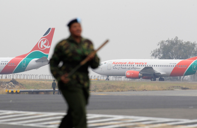 Kenya Airways aircrafts stay grounded after a huge fire left all flights suspended at the Jomo Kenyatta International Airport, as a soldier patrols the grounds, in Kenya's capital Nairobi August 7, 2013 (Reuters / Noor Khamis)