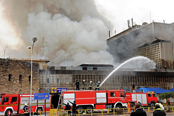Fire crews work to put out a fire outside the burning Jomo Kenyatta international airport on August 7, 2013 (AFP Photo / Stringer) 