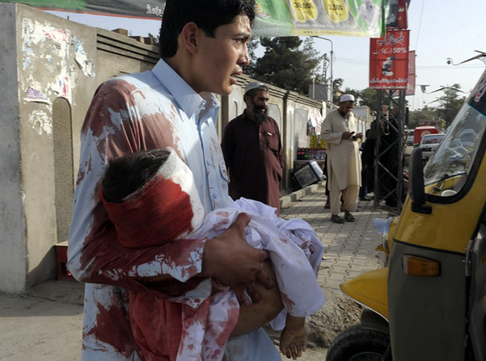 A Pakistani mourner carries the body of a child outside a hospital in Quetta on August 9, 2013, following an attack by gunmen on a mosque. (AFP Photo / Banaras Khan)