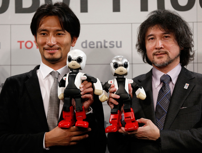 Tomotaka Takahashi (L), CEO of Robo Garage Co and project associate professor, research centre for advanced science and technology, the University of Tokyo, and Fuminori Kataoka, project general manager in the Product Planning Group of Toyota Motor Corp, hold humanoid communication robots Kirobo and Mirata respectively during their unveiling in Tokyo (Reuters)