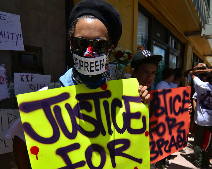 Chy Walton and other supporters hold posters during a vigil for graffiti artist Israel Hernandez-Llach, who died after being shocked by a police officer's Taser, in Miami Beach, Florida August 10, 2013.(Reuters / Gaston De Cardenas)