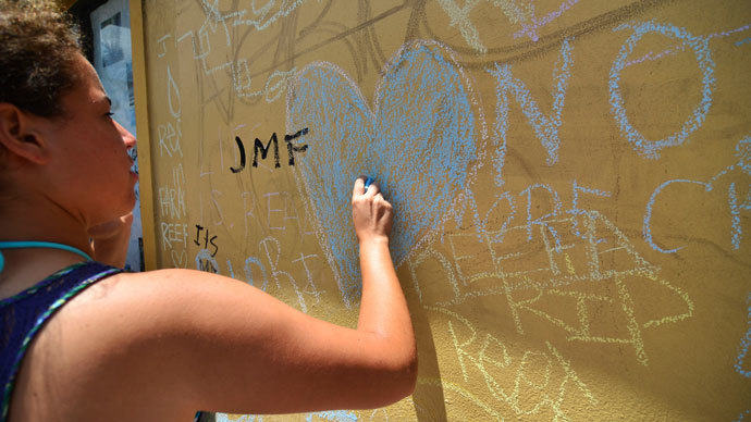 An attendee writes on a wall during a vigil for graffiti artist Israel Hernandez-Llach, who died after being shocked by a police officer's Taser, in Miami Beach, Florida August 10, 2013.(Reuters / Gaston De Cardenas)