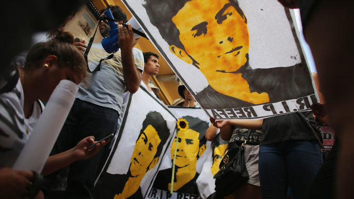 People hold posters during a vigil with a picture of 18-year-old graffiti artist Israel Hernandez-Llach, who died after being tasered by a Miami Beach police officer on August 10, 2013 in Miami Beach, Florida.(AFP Photo / Joe Raedle)
