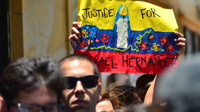 People hold up a poster during a vigil for graffiti artist Israel Hernandez-Llach, who died after being shocked by a police officer's Taser, in Miami Beach, Florida August 10, 2013.(Reuters / Gaston De Cardenas)