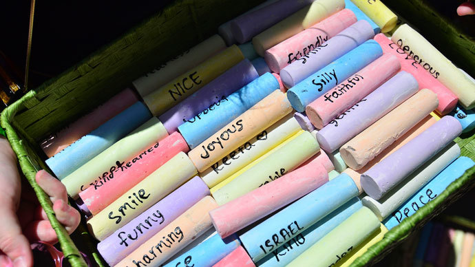 A close up shows chalk with various words, including one with the name of graffiti artist Israel Hernandez-Llach, who died after being shocked by a police officer's Taser, during a vigil for him in Miami Beach, Florida August 10, 2013. (Reuters / Gaston De Cardenas)