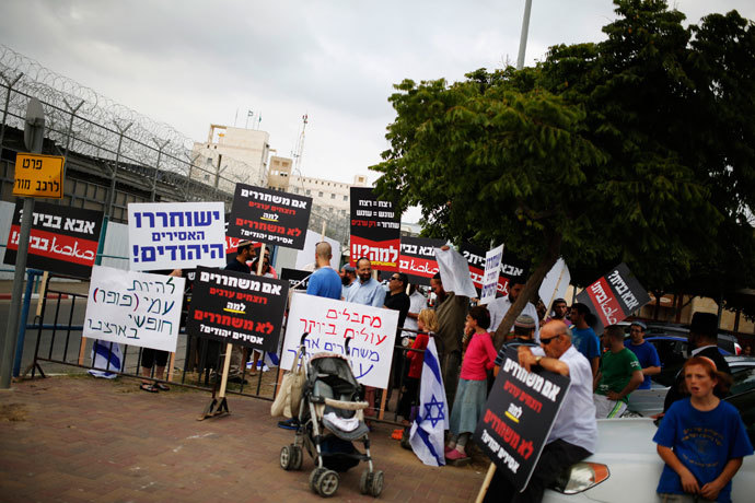 Protesters hold placards during a demonstration calling for the release of Israeli prisoners in response to Israel's expected release of Palestinian prisoners, outside the Ayalon prison in the city of Ramle near Tel Aviv August 13, 2013.(Reuters / Amir Cohen)