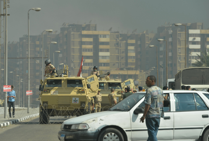 Egyptian military vehicles block a road leading to the Rabaa al-Adawiya protest camp in Cairo as Egyptian police try to disperse supporters of Egypt's ousted president Mohamed Morsi on August 14, 2013 (AFP Photo / Khaled Desouki) 