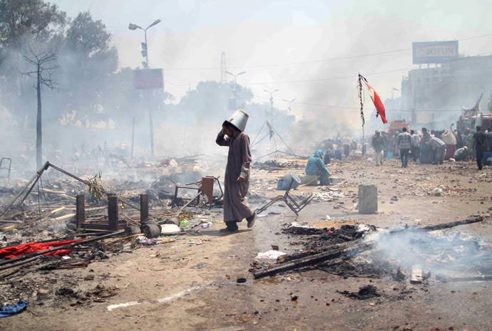 A supporter of Egypt's ousted president Mohamed Morsi walks through the debris following clashes with police in Cairo on August 14, 2013, as security forces backed by bulldozers moved in on two huge pro-Morsi protest camps, launching a long-threatened crackdown that left dozens dead. (AFP Photo)