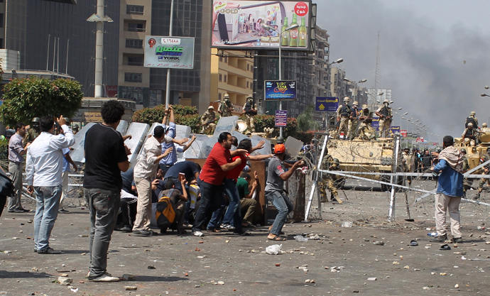 Members of the Muslim Brotherhood and supporters of ousted Egyptian President Mohamed Mursi throw stones at riot police and the army during clashes around the area of Rabaa Adawiya square, where they are camping, in Cairo August 14, 2013 (Reuters / Asmaa Waguih)