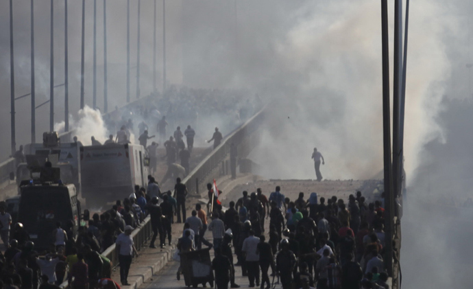 Members of the Muslim Brotherhood and supporters of ousted Egyptian President Mohamed Mursi flee from tear gas and rubber bullets fired by riot police during clashes, on a bridge leading to Rabba el Adwia Square where they are camping, in Cairo August 14, 2013 (Reuters / Amr Abdallah Dalsh)