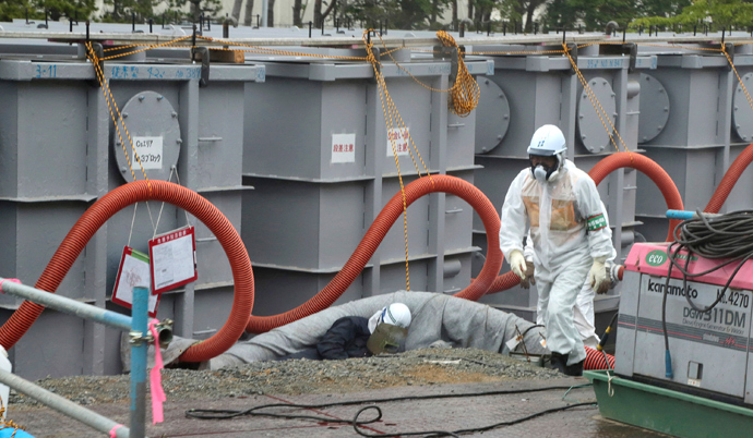 A worker walks in front of water tanks at Tokyo Electric Power Company's (TEPCO) tsunami-crippled Fukushima Daiichi nuclear power plant in Fukushima prefecture (Reuters / Noboru Hashimoto / Pool) 