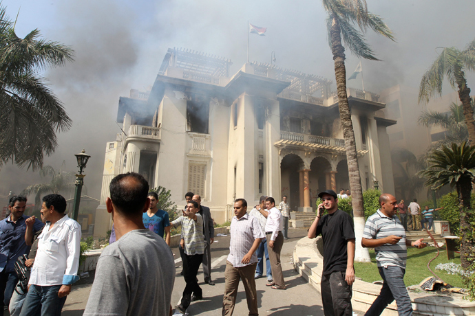 People gather outside a government building after it was set ablaze in Giza's district of Cairo, August 15, 2013 (Reuters / Muhammad Hamed) 