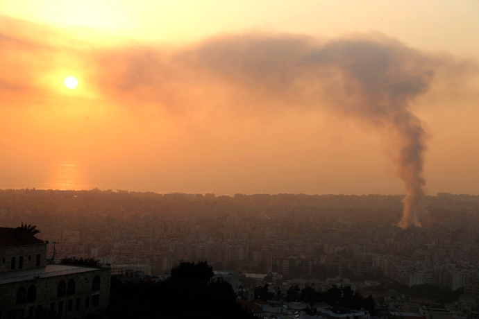 Smoke rises behind buildings from the site of an explosion in Beirut's southern suburbs, August 15, 2013 (Reuters / Mohamed Azakir) 