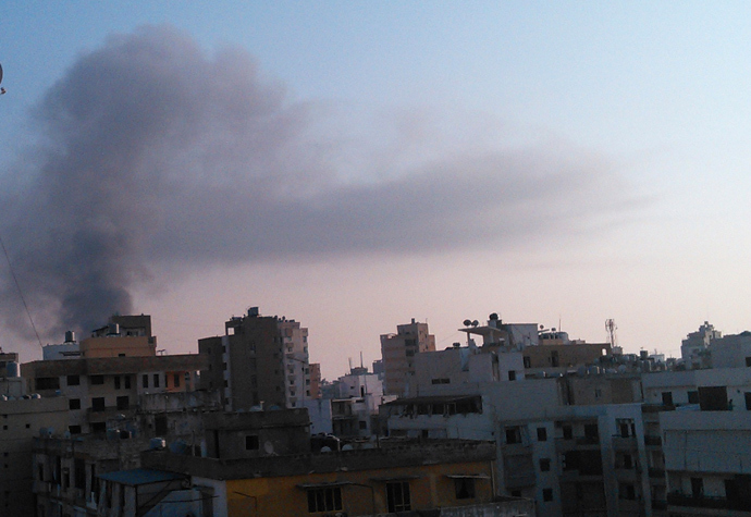 Smoke rises behind building from the site of an explosion in Beirut's southern suburbs, August 15, 2013 (Reuters / Mahmoud)