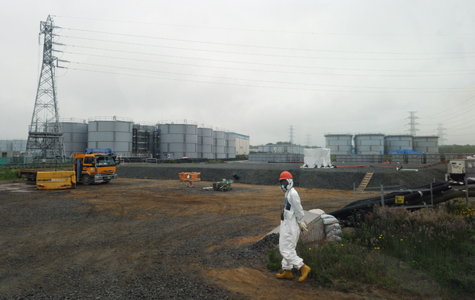 A construction worker walks near water tanks at Japan's Fukushima Dai-ichi nuclear plant in Okuma town in Fukushima prefecture (AFP Photo)