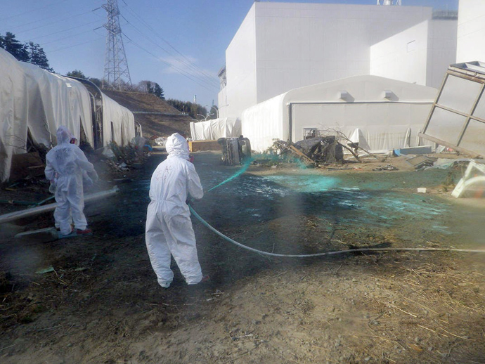 Workers spraying resin on the ground near the reactor buildings to protect the spread of radioactive substances at TEPCO's Fukushima Daiichi nuclear power plant at Okuma town in Fukushima prefecture (AFP Photo)