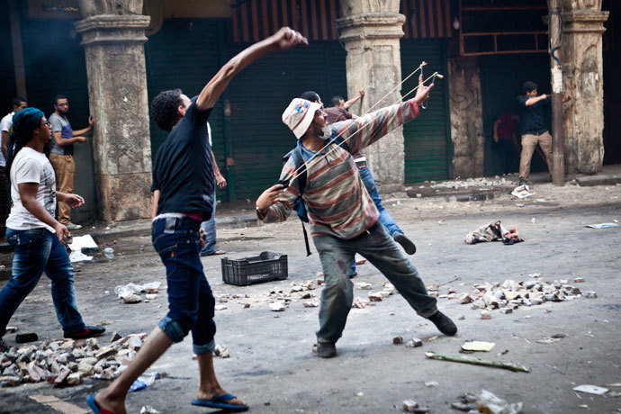 Supporters of ousted president Mohamed Morsi throw stones as they clash with security officers in Cairo's Ramses Square, on August 16, 2013.(AFP Photo / Virgnie Nguyen Hoang)