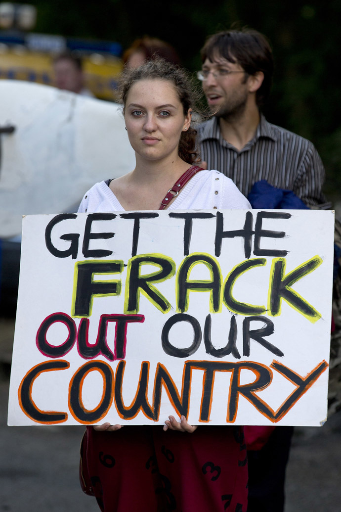 An anti-fracking and climate protester holds a placard that reads "Get the frack out our country" as she joins a march towards the drill site operated by British energy firm Cuadrilla in Balcombe in southern England, on August 18, 2013. (AFP Photo/Justin Tallis)