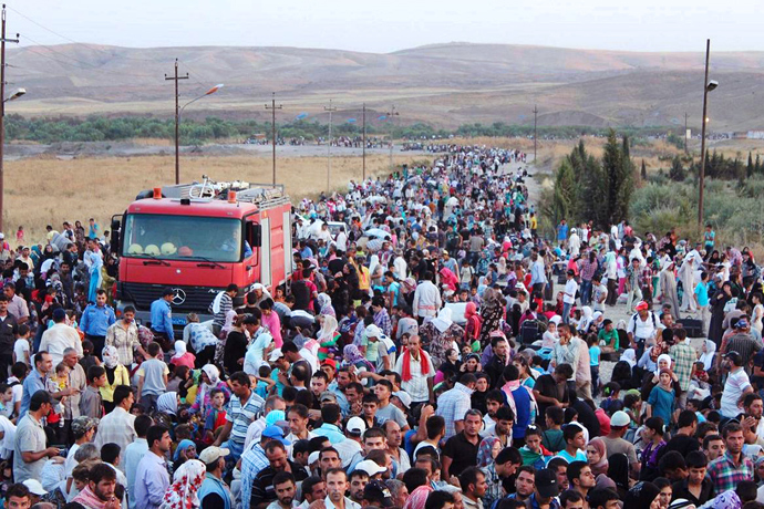 Thousands of Syrians streaming across a bridge over the Tigris River and entering the autonomous Kurdish region of northern Iraq (AFP Photo)