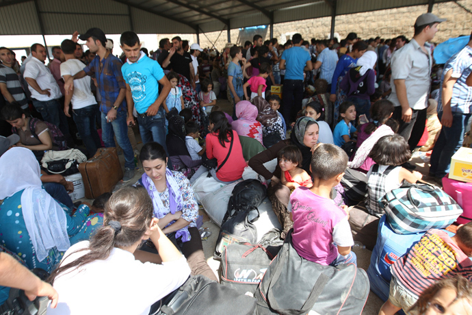 Syrian refugees, fleeing the violence in their country, wait to cross the border into the autonomous Kurdish region of northern Iraq, August 19, 2013 (Reuters / Azad Lashkari)