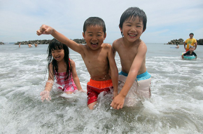 Children swim in the sea at the Nakoso beach in Iwaki city in Fukushima prefecture, 65km south of the crippled TEPCO nuclear power plant, on July 16, 2012 as the beach opened for the season, the first time since the massive earthquake and nuclear accident on March 11, 2011. (AFP Photo)